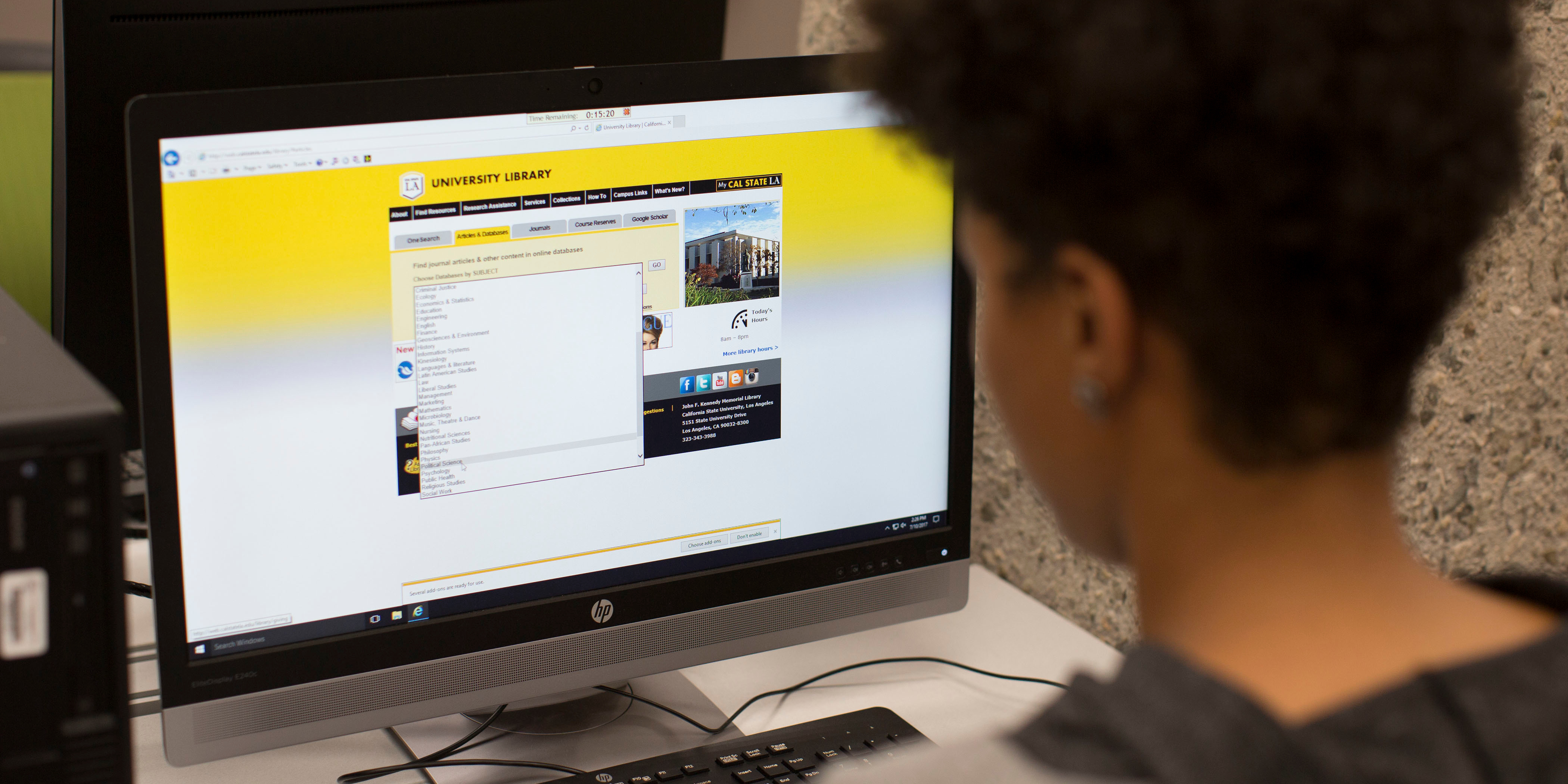 Over-the-shoulder view of student looking at Cal State LA library website on computer