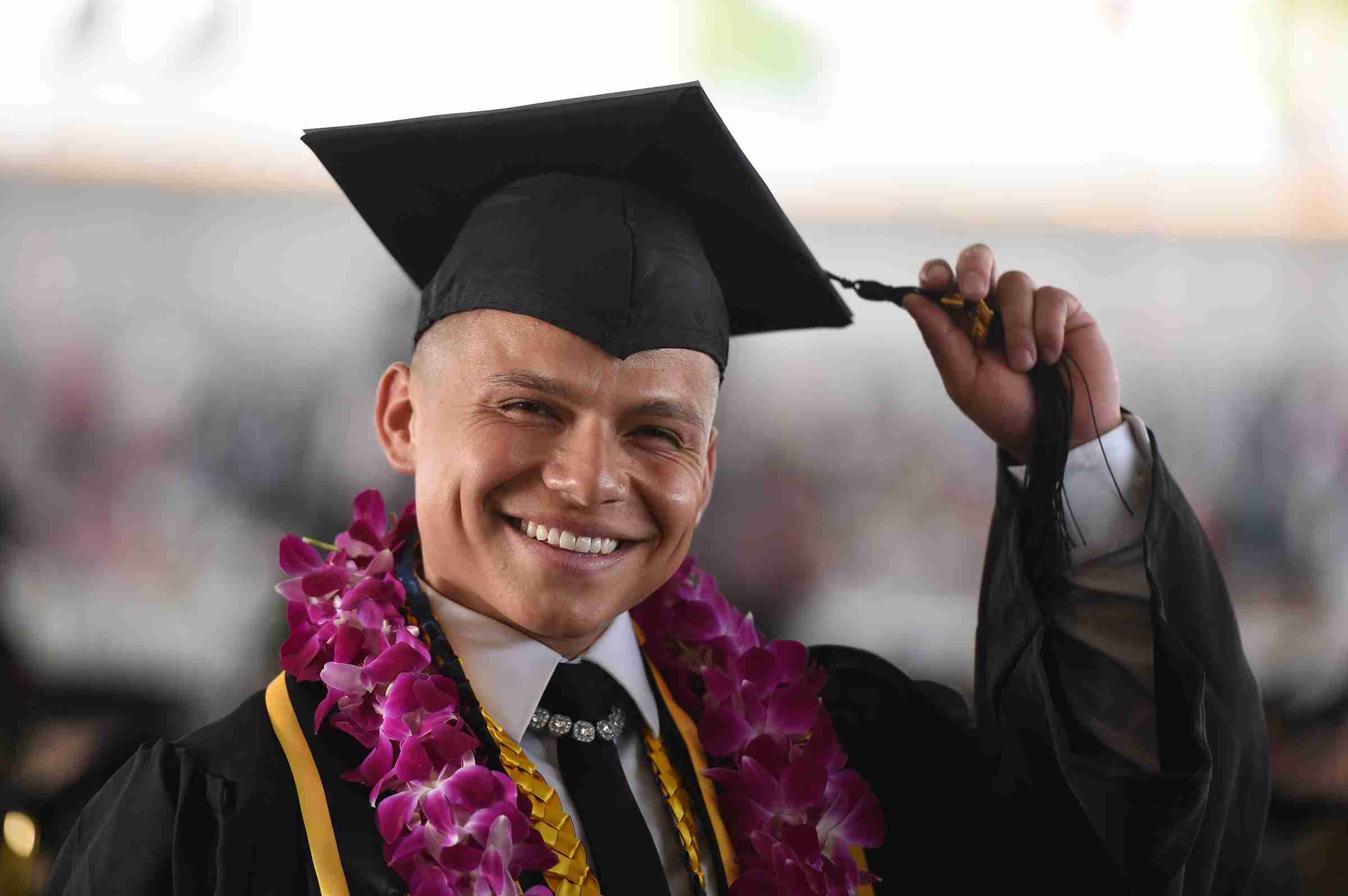 Male graduate wearing cap and gown.