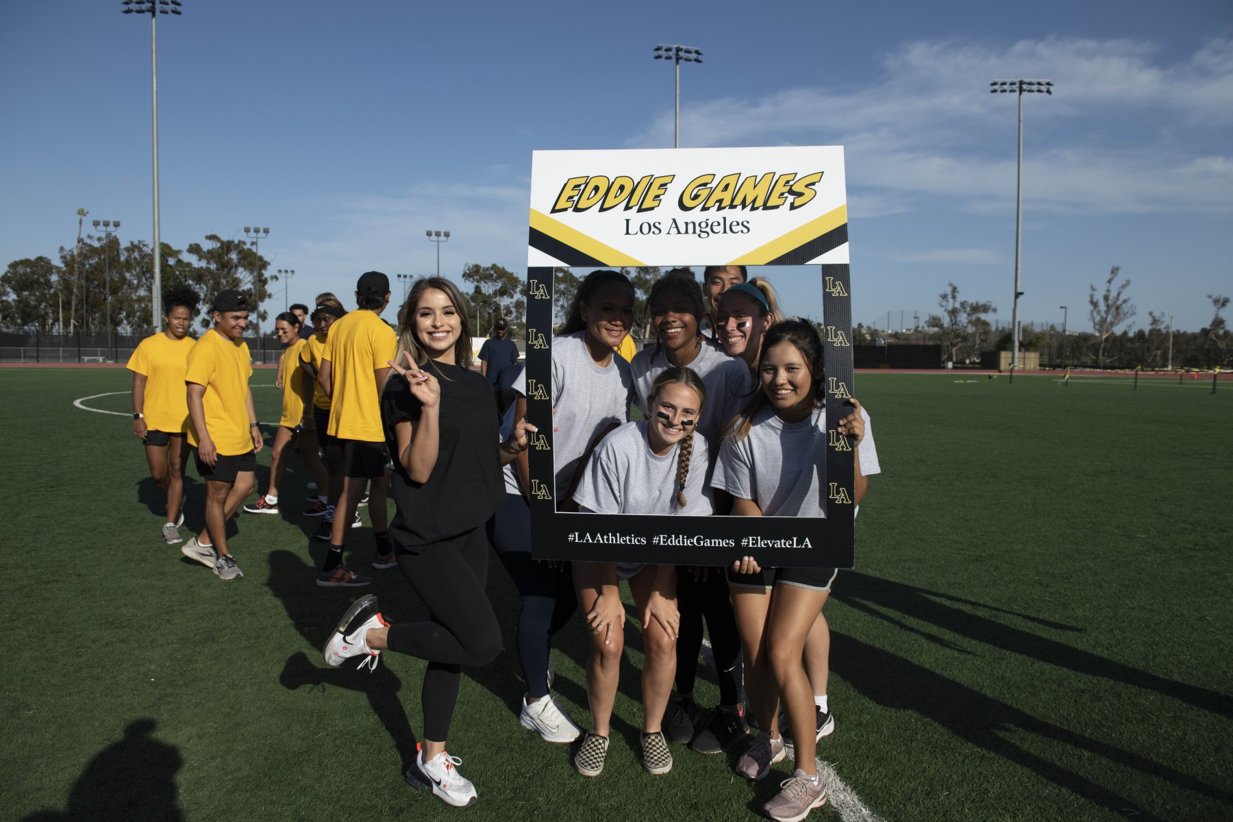 A group of students posing behind a life-sized Eddie Games frame.