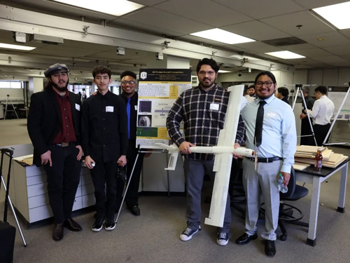 Capstone Expo students hold 3D aircraft in lab
