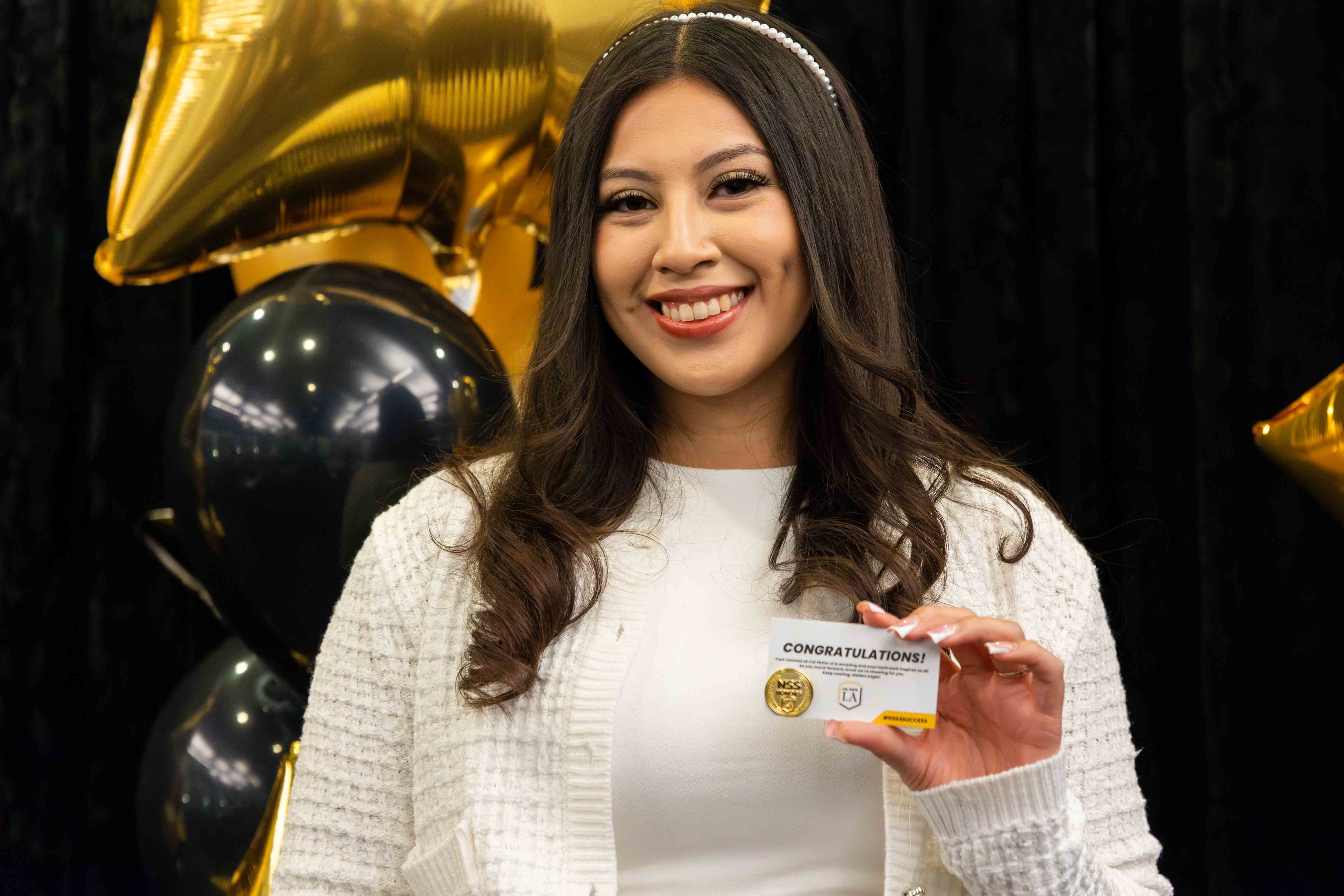 Cal State LA student holding up NSS Honors Pin