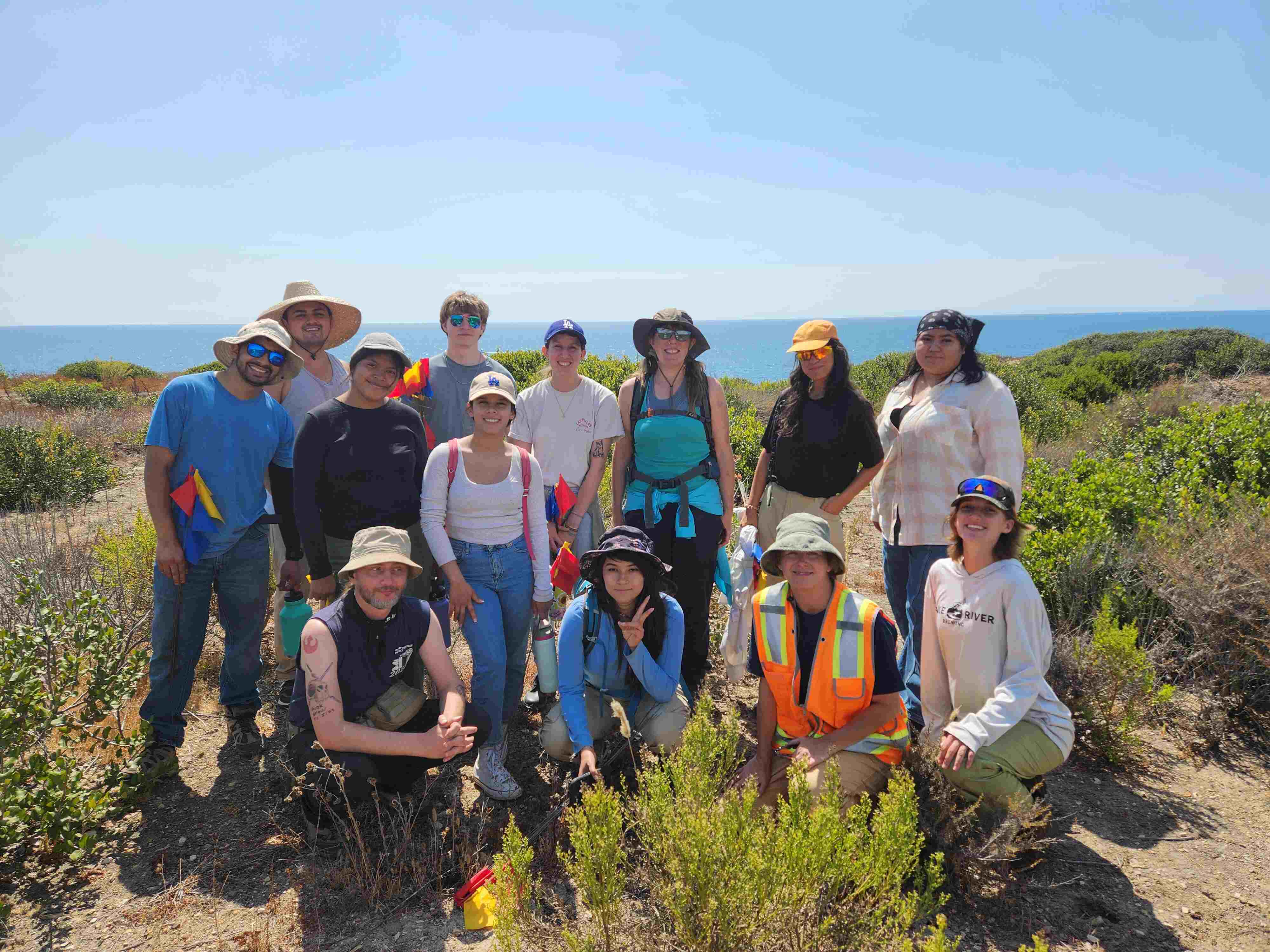 Group of students posing in front of coastline