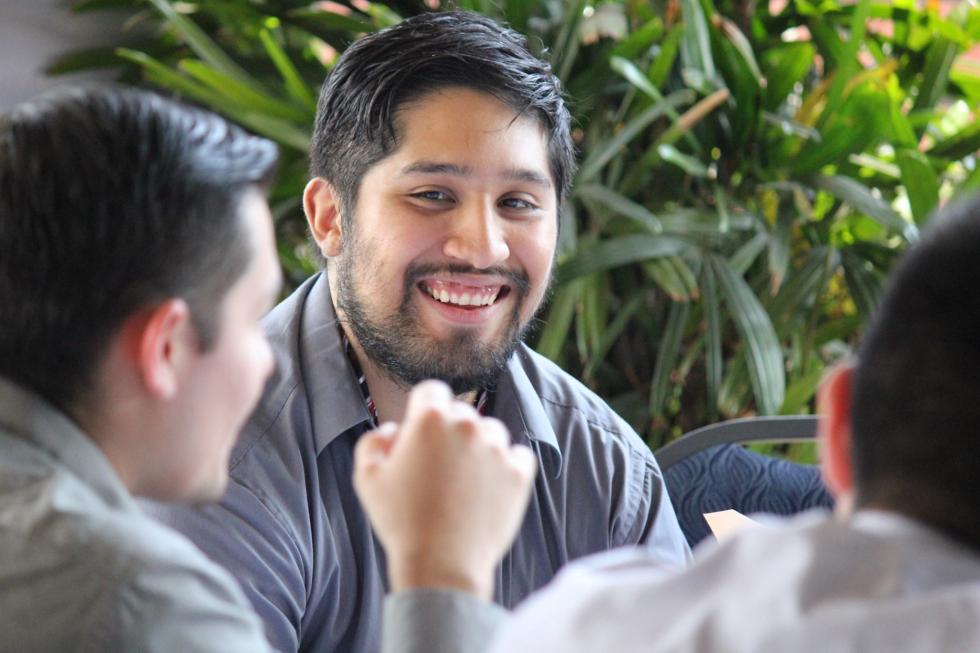 Launch 2017-18 male student smiles while in conversation.