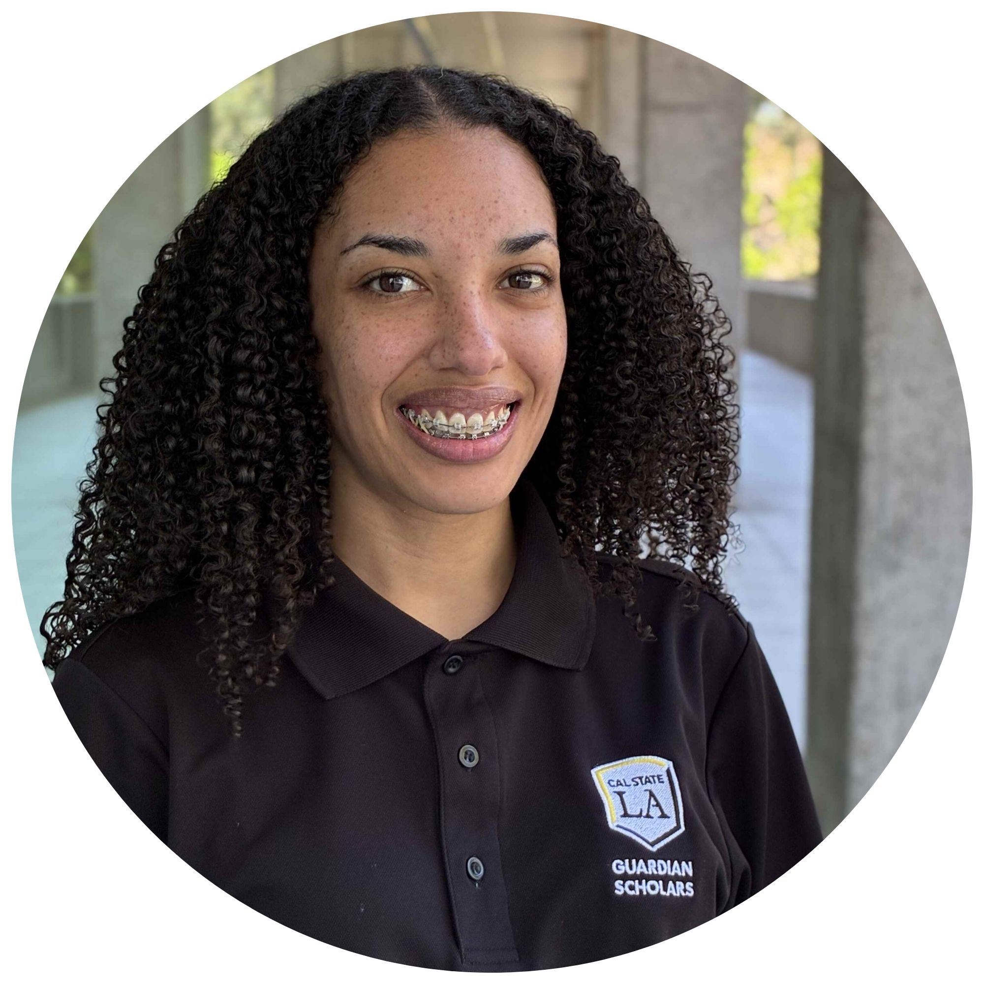 Kely Taylor, a peer mentor at Cal State LA, smiling and wearing a black Cal State LA Guardian Scholars polo shirt