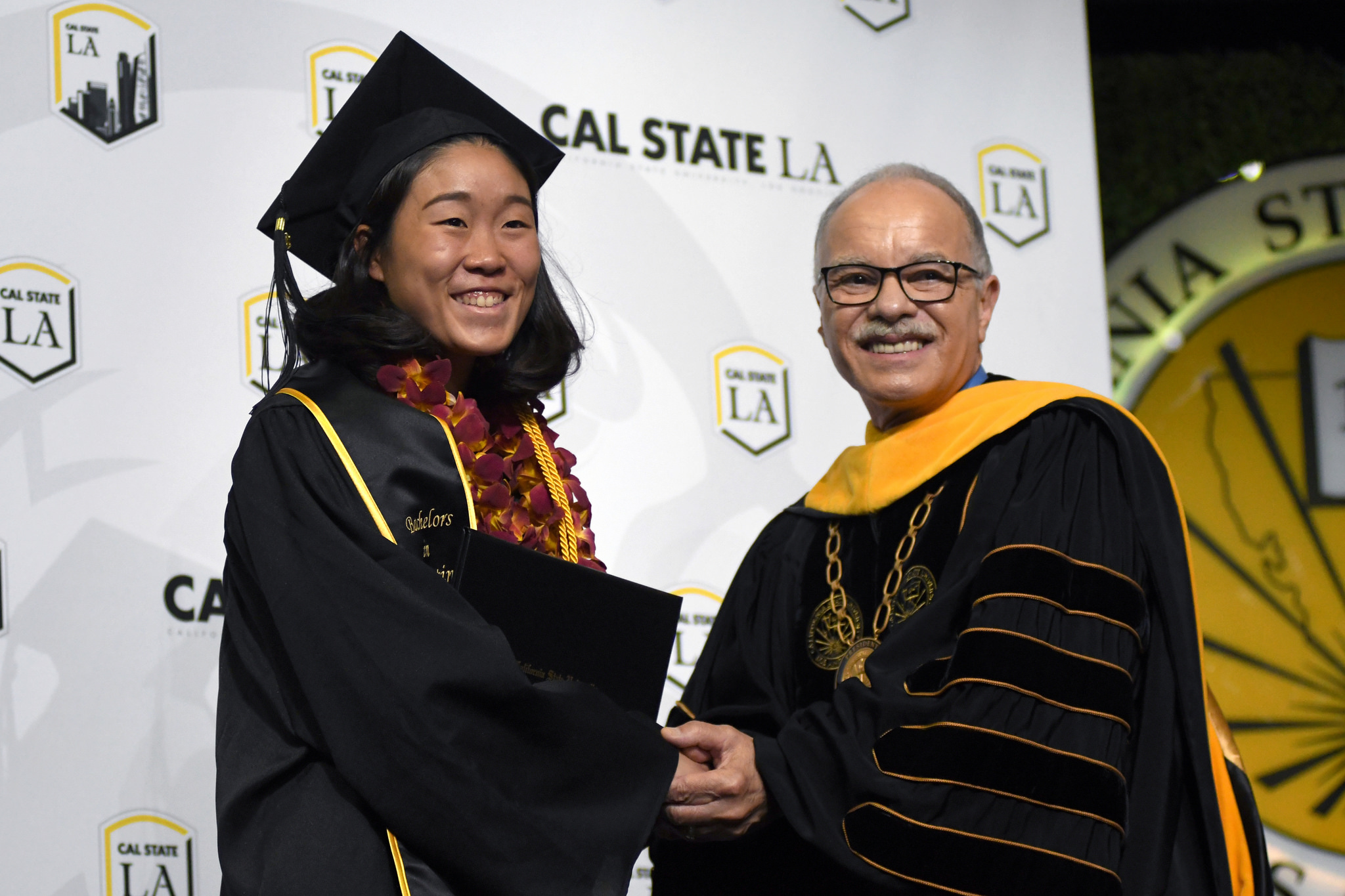 A graduate shakes President Covino's hand