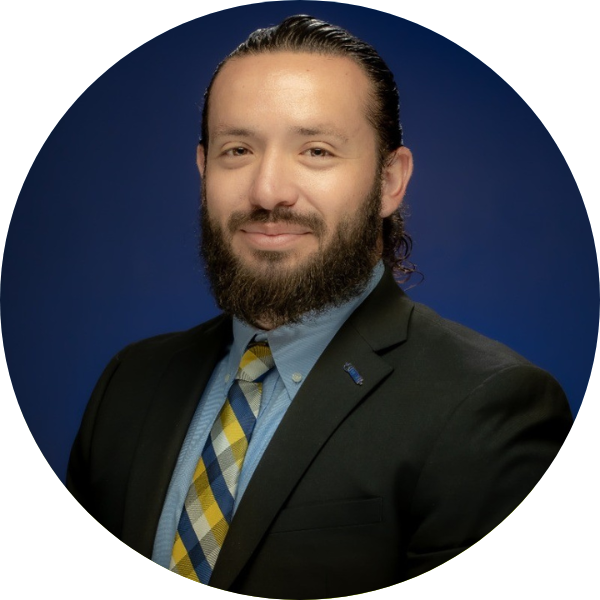 Man with a beard smiling with a blue background.