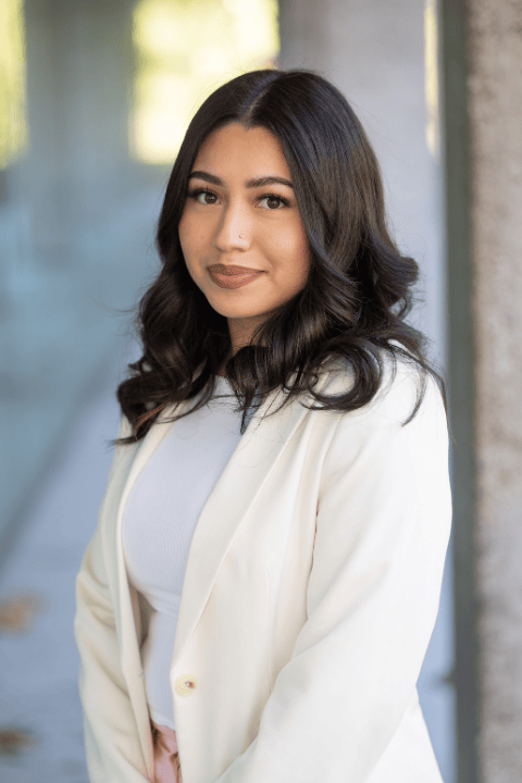 A person with black shoulder length hair smiling.