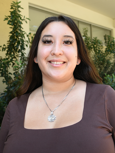 A person with long hair smiling.