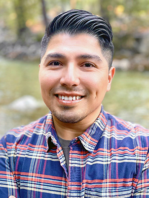 A person with short hair smiling.