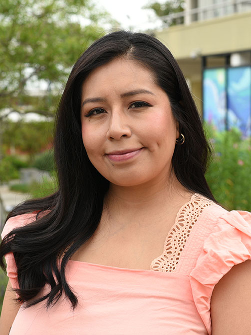 A person with long hair smiling.