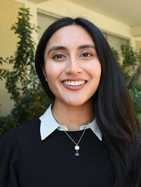 A person with long hair smiling.