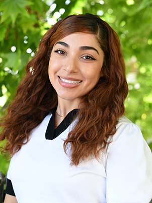 Girl with red long hair and a white shirt smiling 