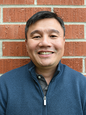 Person smiling with short dark hair