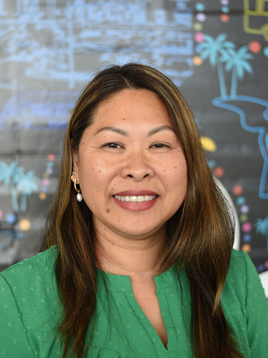 A person with long hair smiling.