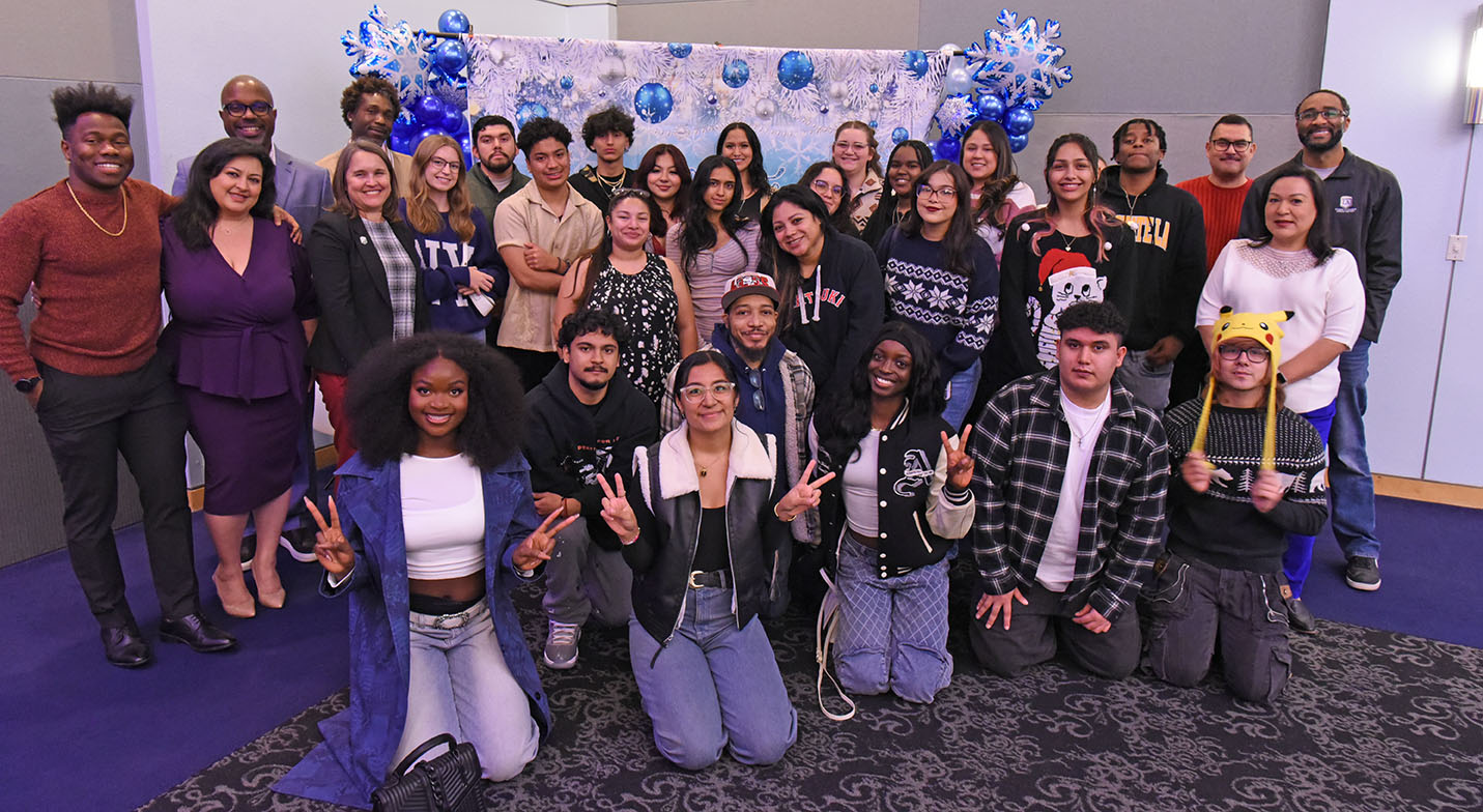 A large group of people indoors smiling.