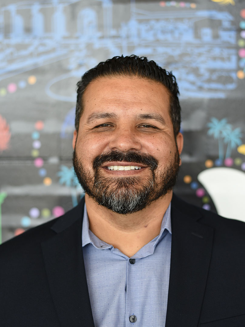 A person with short hair and beard smiling.