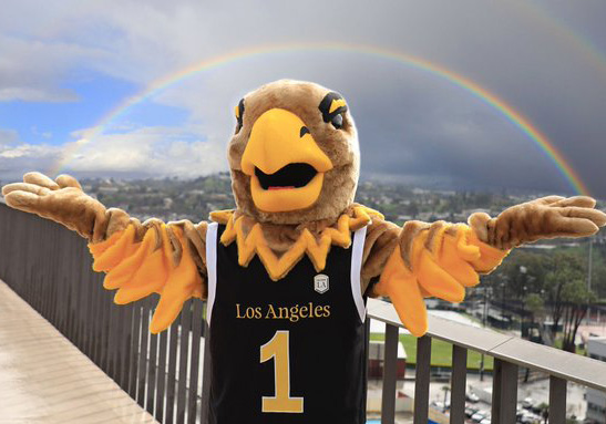 Eddie the Golden Eagle with arms spread out pretending to hold a rainbow.