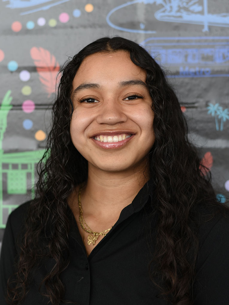 A person with long wavy hair smiling.
