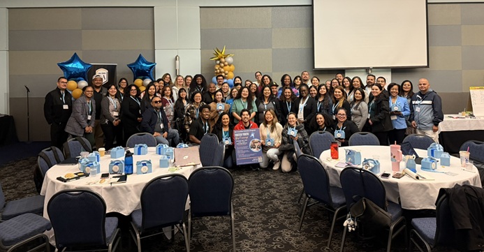 A group of individuals smiling and holding up certificates of achievement