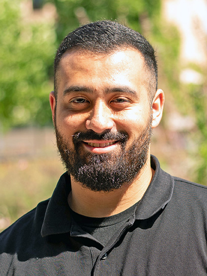 A person with short hair and beard smiling.