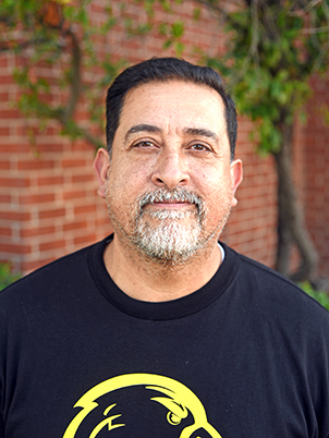 A person with short hair and a goatee smiling.