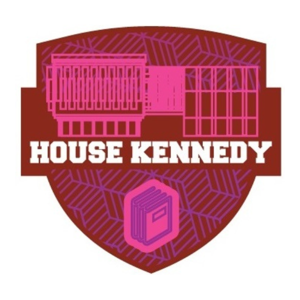 A red colored shield with magenta designs inscribed within. The text reads: "House Kennedy".