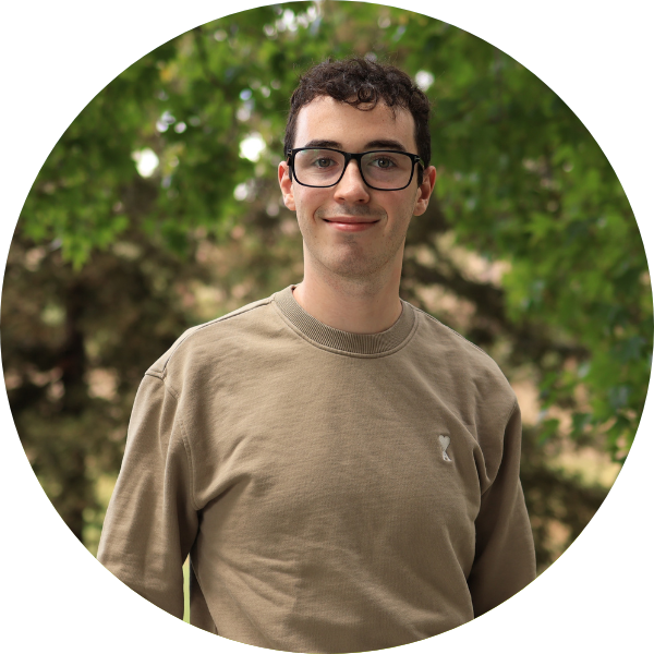A white man with glasses and green shirt smiling at the camera.