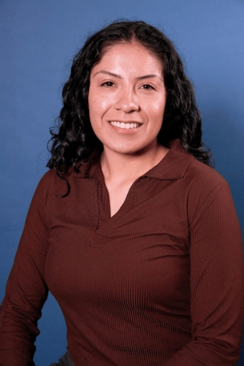 A person with dark hair smiling.