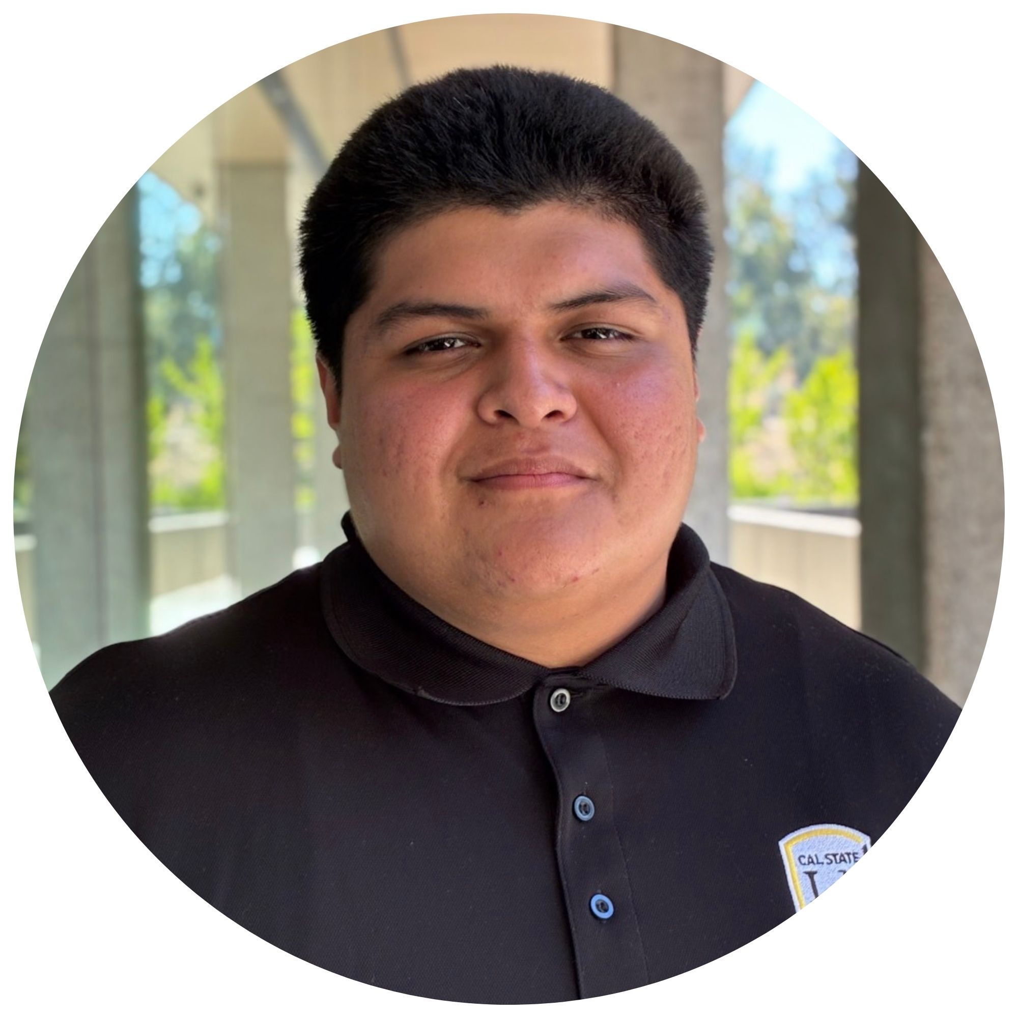 Joseph Diaz, the student assistant at Cal State LA, smiling and wearing a black Cal State LA Guardian Scholars polo shirt