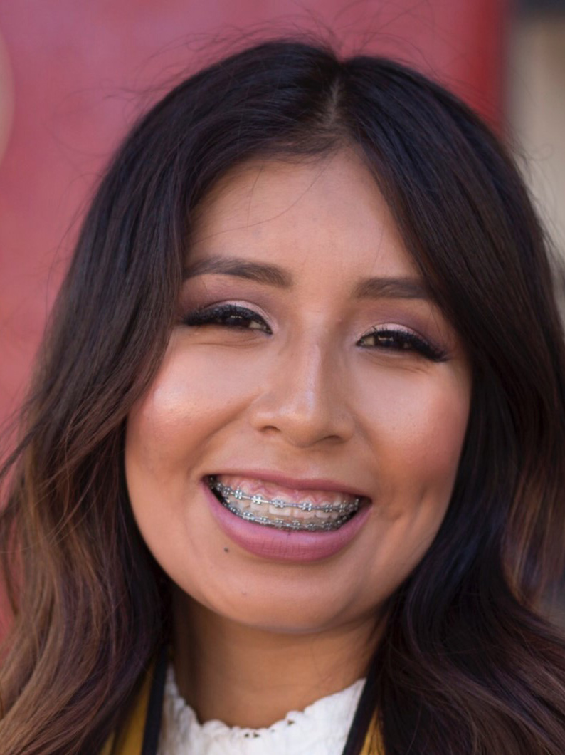 A person with long hair smiling.