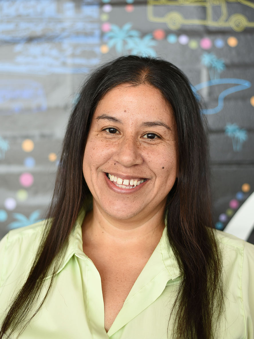 A person with long hair smiling.