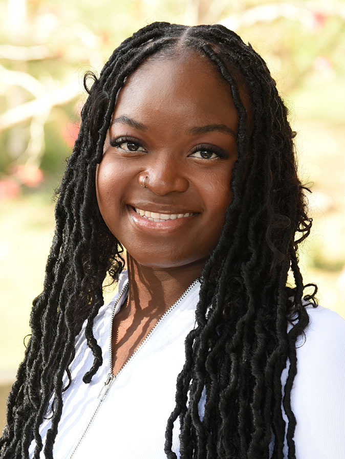 A person with long hair smiling.