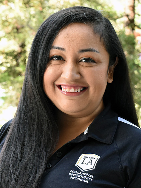 A person with long, dark hair smiling.