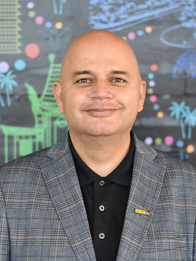 A person wearing a We Are LA lapel pin, smiling.