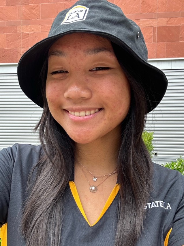 Student in bucket cap smiling.