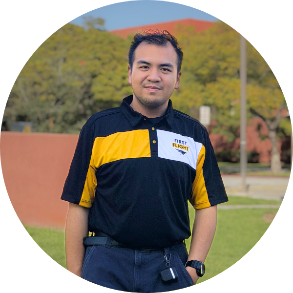 A student wearing a black polo with his hand in his pocket.