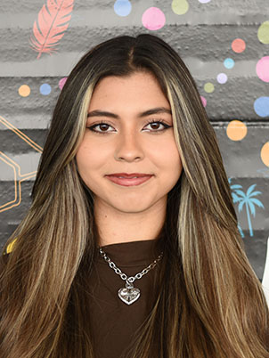 A person with long hair smiling.