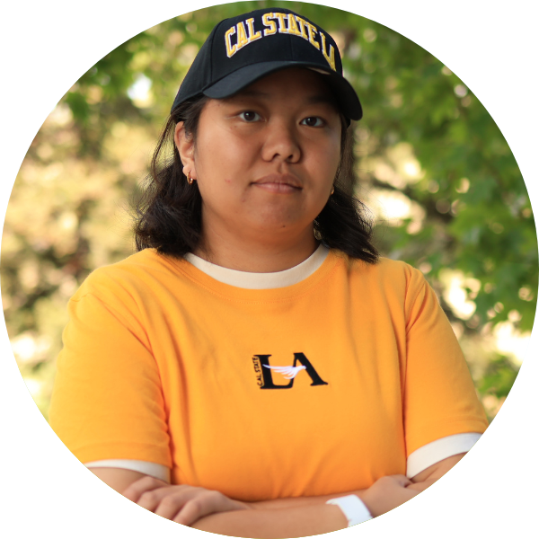 A woman with a black hat and a yellow T-shirt glancing at the camera.