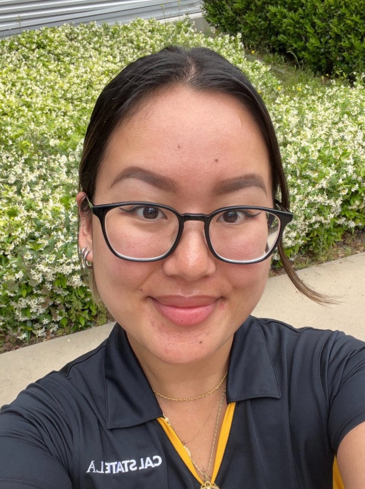 Student with glasses smiling.