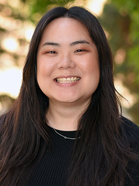 A person with long hair smiling