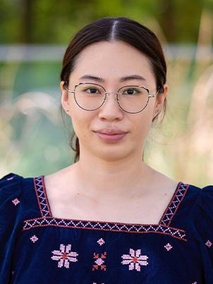 A person with glasses smiling slightly.