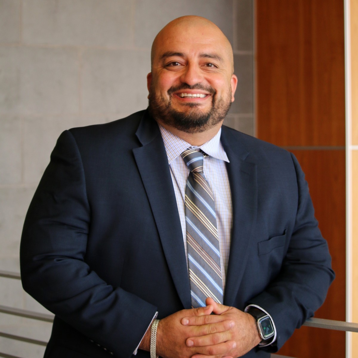 Headshot of Alejandro Macias in a blue suit and tie.