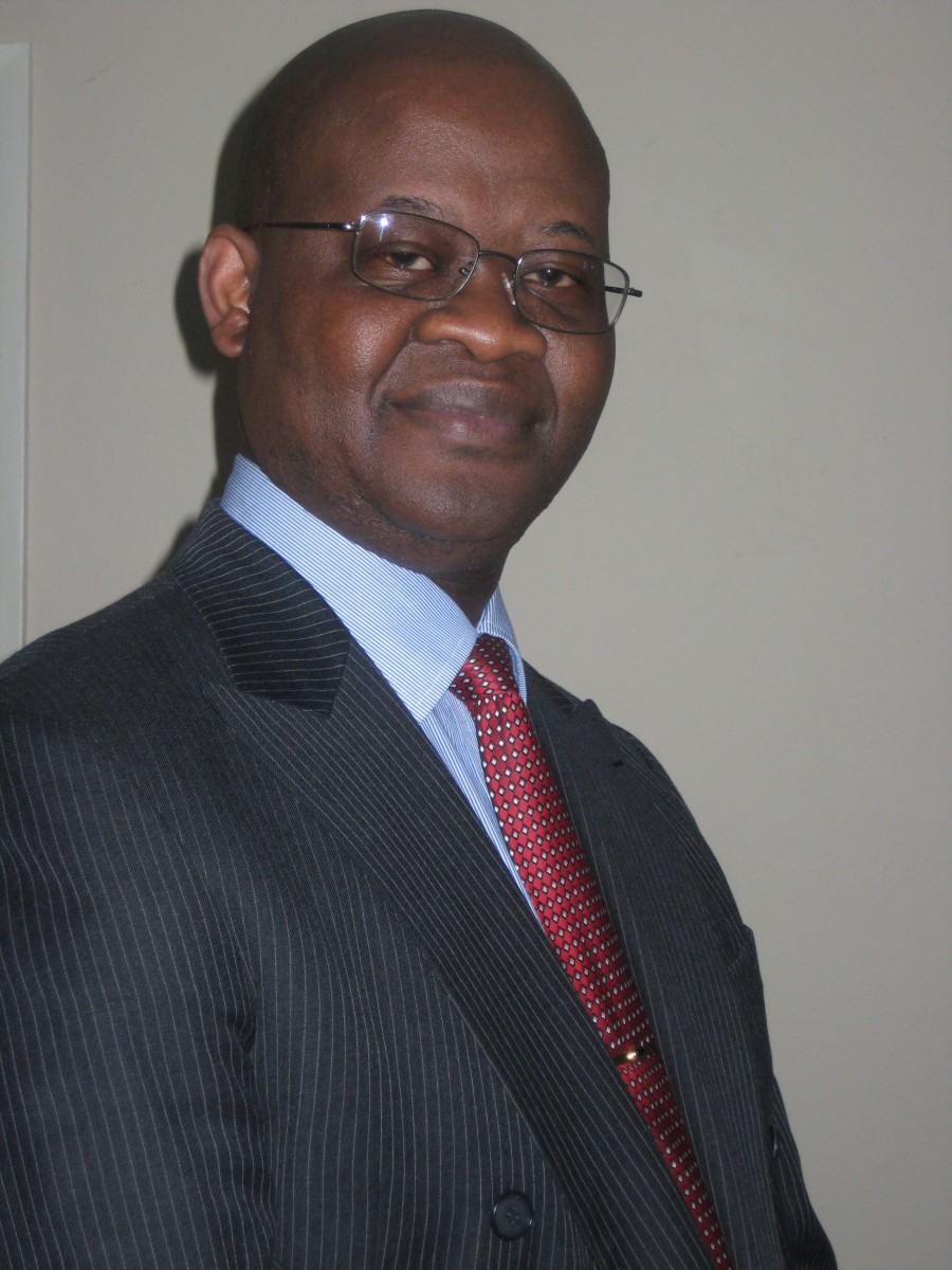 African-American man with glasses wearing a stripped black suit, blue collared shirt and red tie