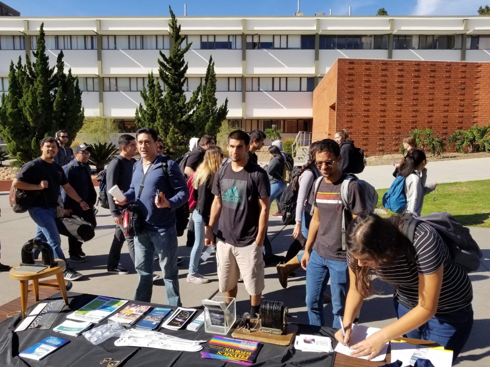 Students visit the table on Physics Awareness Day.