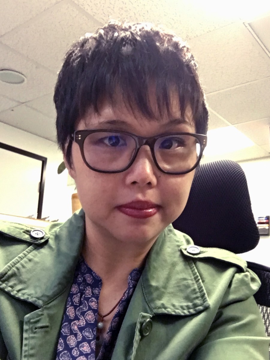 Person with short hair wearing thick-rimmed glasses.
