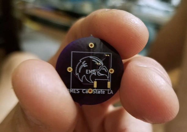 Student holding biomedical device with Cal State LA BMES Logo on it