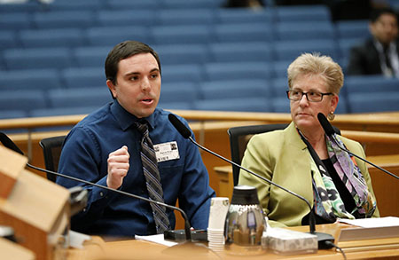 Cal State LA student Patrick Flinner explains his team's project to the Board of Supervisors as Dean Emily Allen looks on