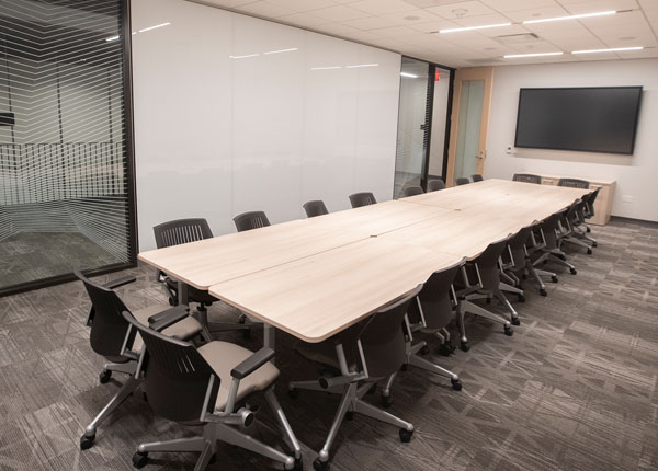 A modern conference room displaying a large table that can accommodate many people.