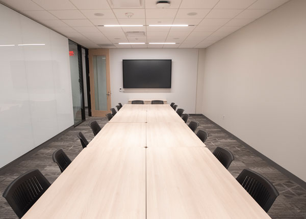 A modern conference room displaying a large table that can accommodate many people.