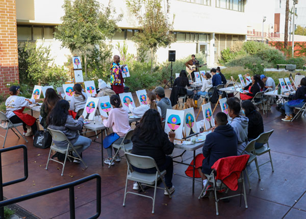 A large group of painting on a sunny day in a drought-tolerant garden.